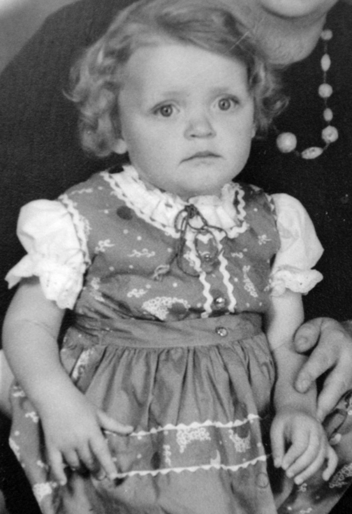 Barbara Friedl-Stocks im zarten Alter von vier Jahren. Barbara weist auf das Satanszeichen, das sie mit ihrer rechten Hand macht. 