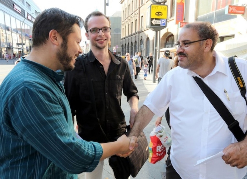 Muslimisch-jüdischer Handschlag in Neukölln, im Hintergrund freut sich Armin Langer, Foto: © Salaam Shalom 